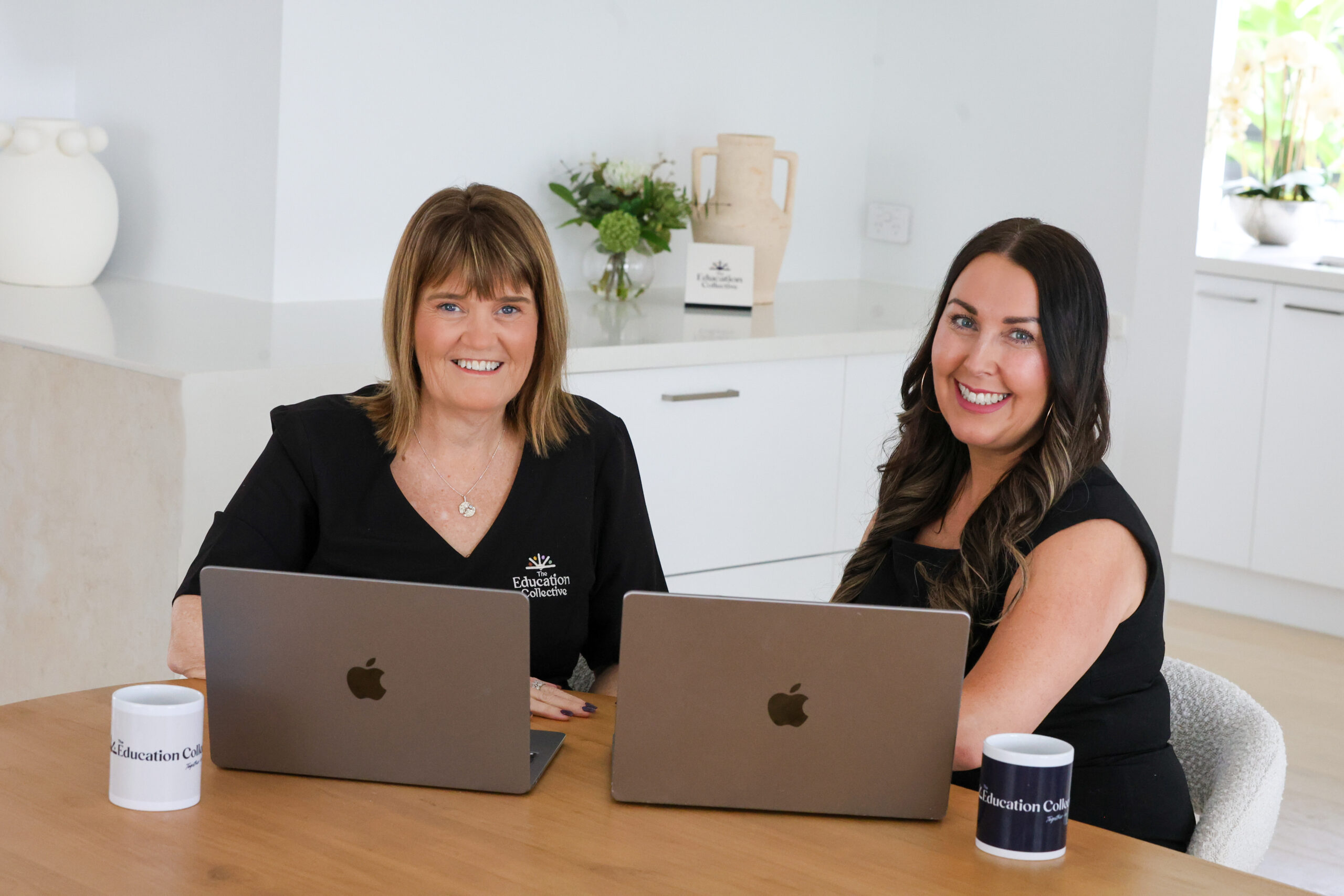 Professionals collaborating at a laptop in an office setting, representing childcare centre management and operational support.